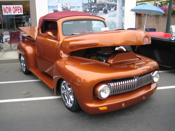 an orange old fashion truck on the street