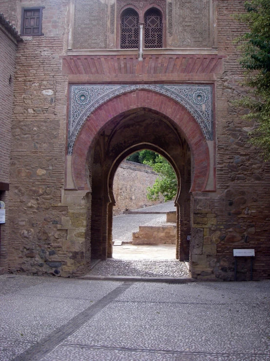 a street that has stone arches and a bench under it