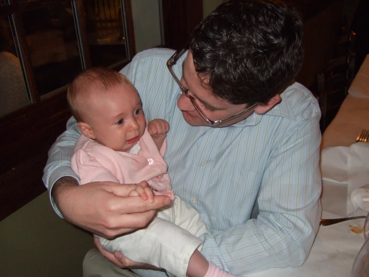 a man holding a baby who is dressed in pajamas