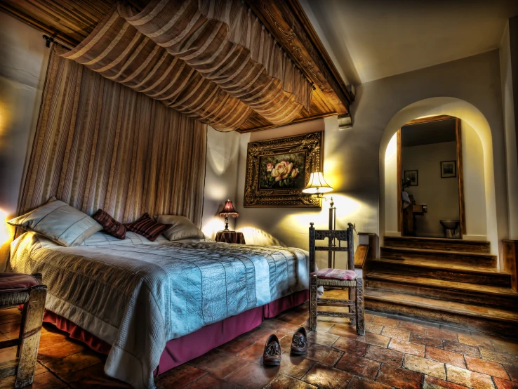 a bedroom with a bed a chair and an archway