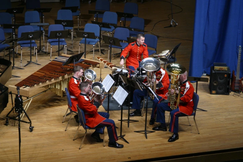 four men in uniform standing next to musical instruments