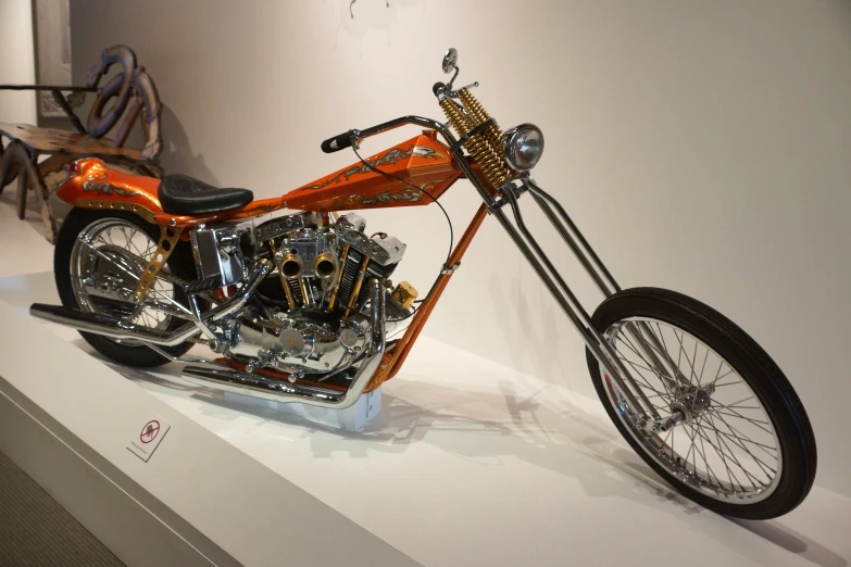 a motorcycle on display at a museum near a chair