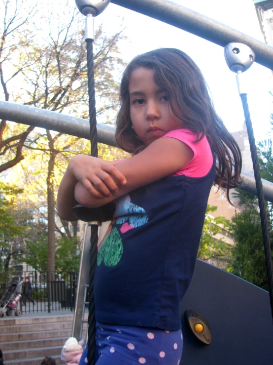  on swings in park setting with a lot of trees