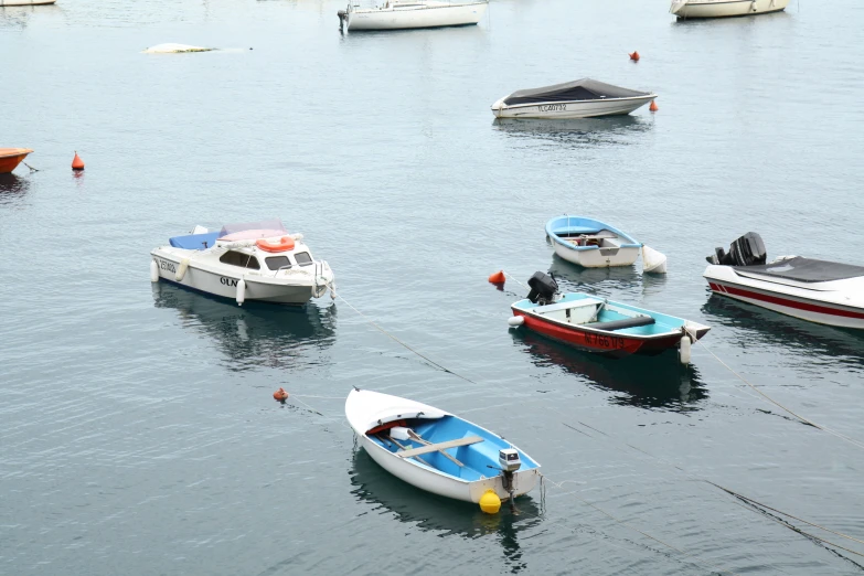 many different boats are in the water and some one is standing