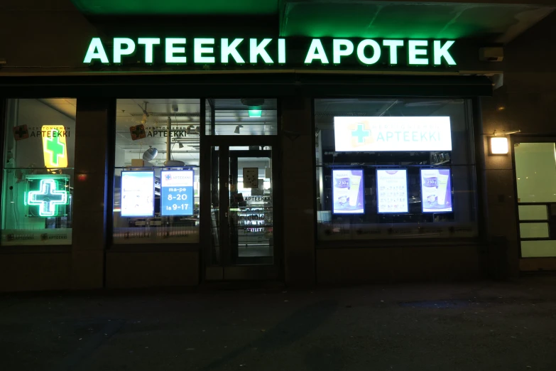 a green lighted sign on a building at night