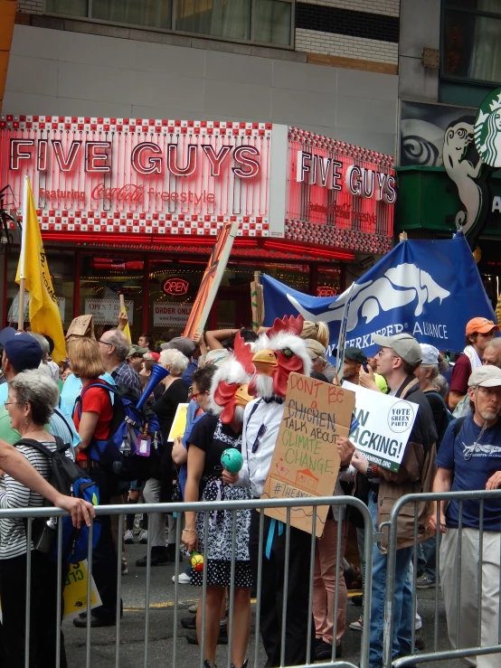 a group of people with their faces covered by their hands standing near some barricades