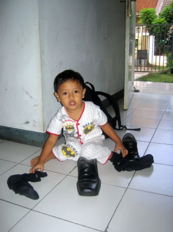 a little boy is sitting on the floor