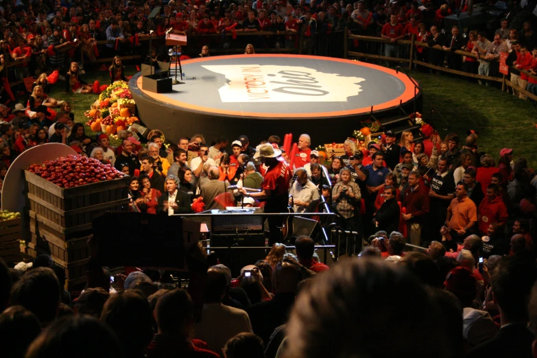 a large crowd is watching a man stand at a stage in front of an audience