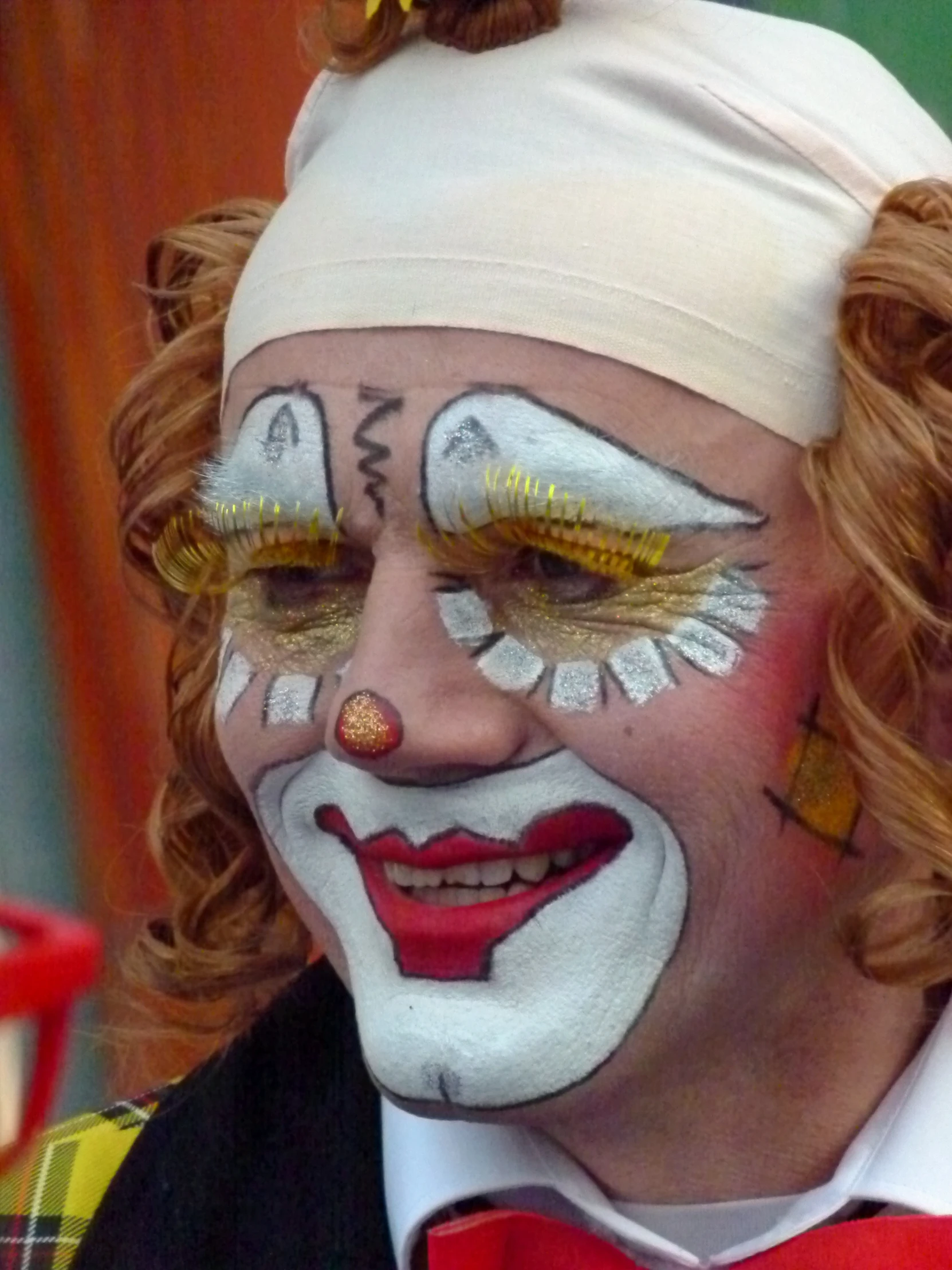 a clown with painted face and yellow eye makeup