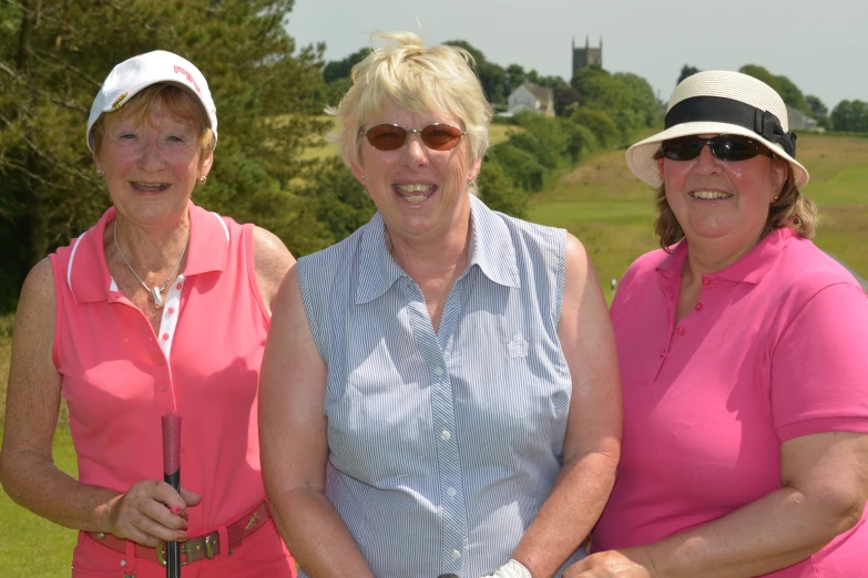 three women standing next to each other with golf clubs