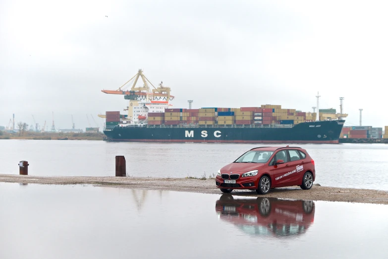 a car is parked on the beach near the water