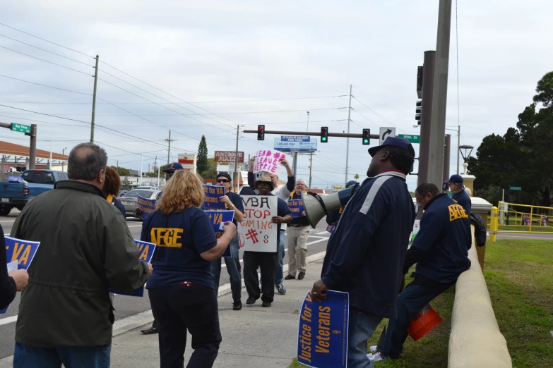 protesters on the sidewalk hold placares with their hands