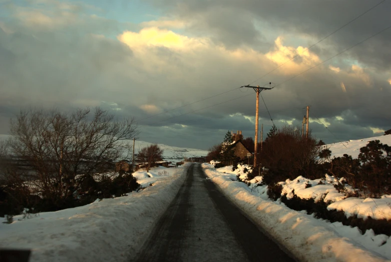 a snowy, road going through a town in the background