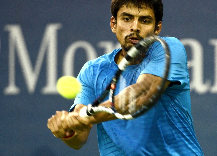 a man hitting a tennis ball with a tennis racket