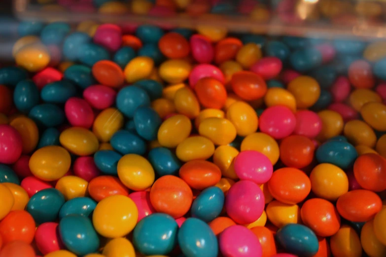 many colorful candy balls arranged around the inside of a container