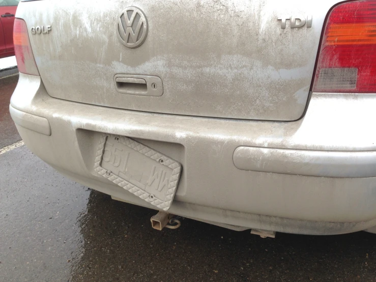 a front end of a grey volkswagen tike parked next to another white one