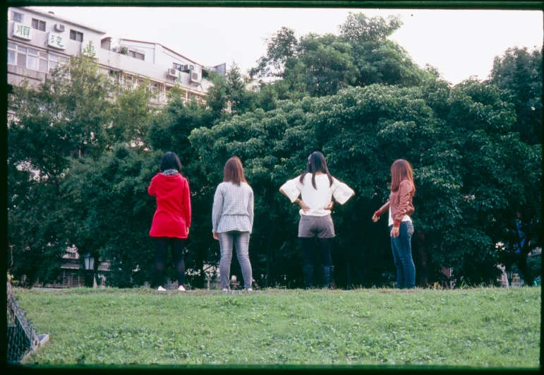 three girls stand watching as two woman walk