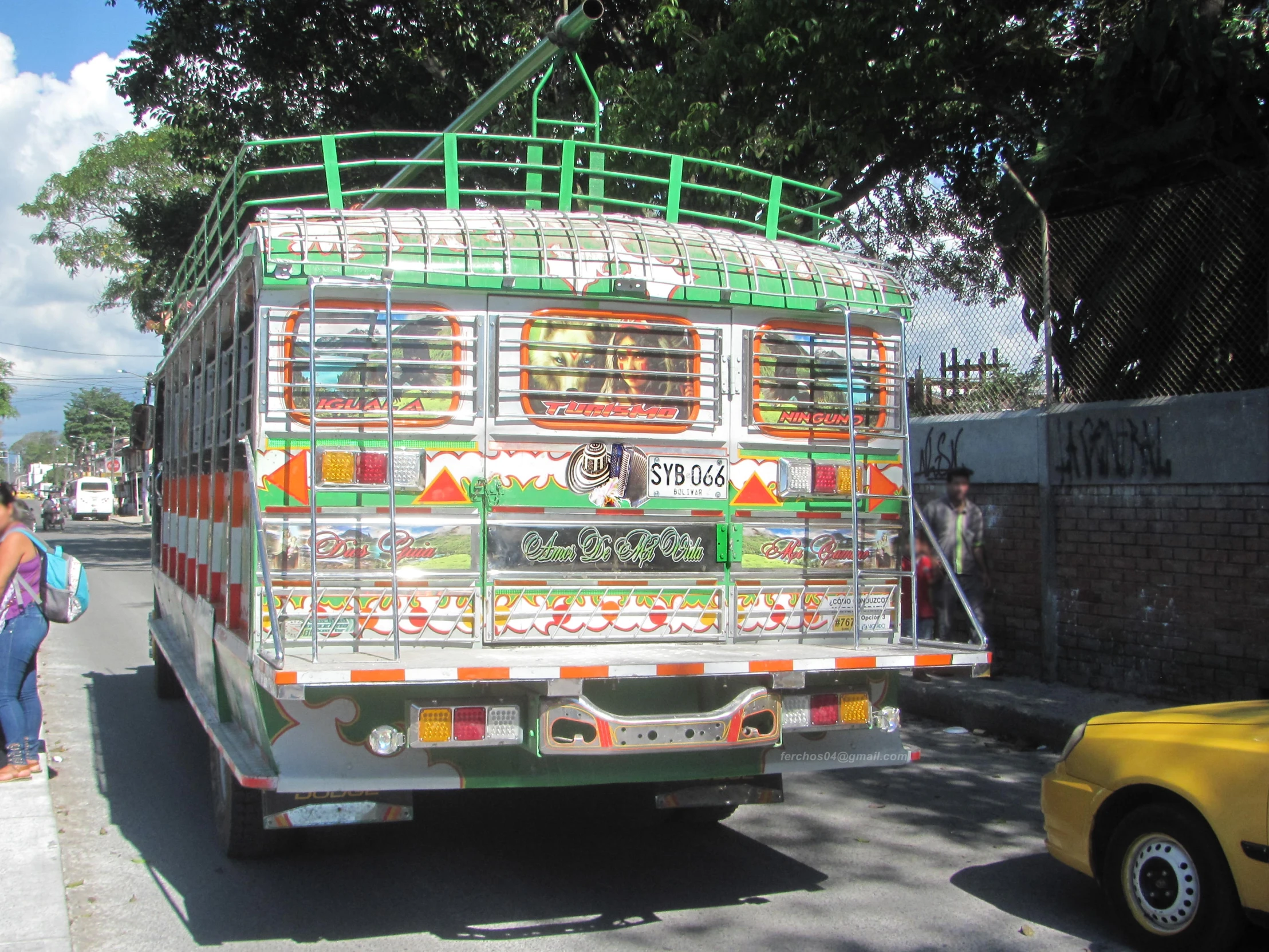 a woman and man with their backs to the back of a bus