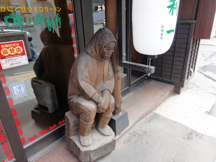 there is a wooden statue sitting in front of a window