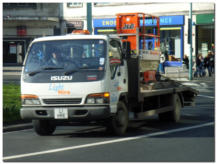 a truck drives down the road with some people in the back