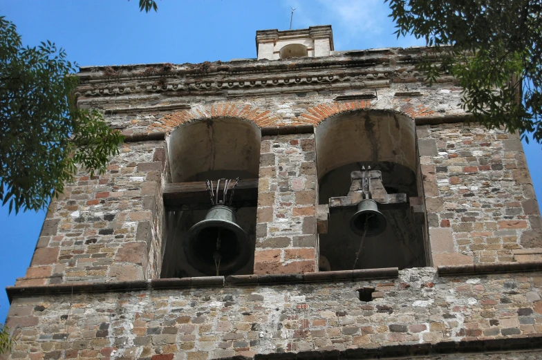 two bell on top of a tower under a blue sky