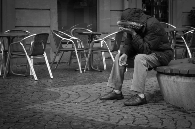 a man sitting on top of a stone bench