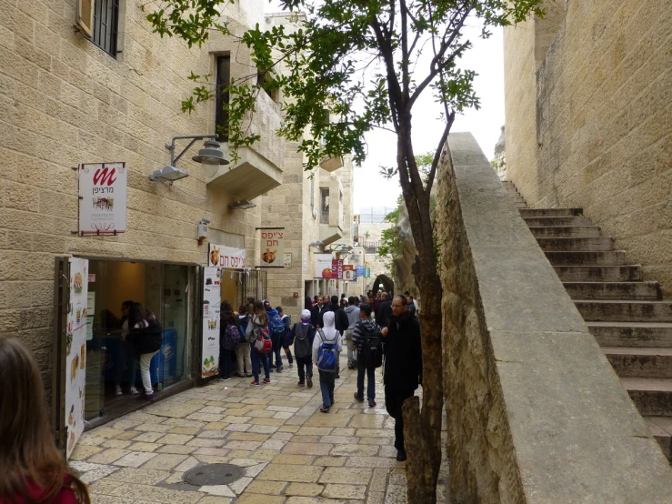 many people walking up a stone lined alley