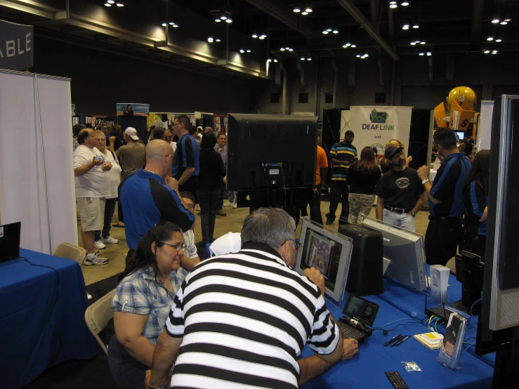 people stand and sit in the room while a man takes pographs