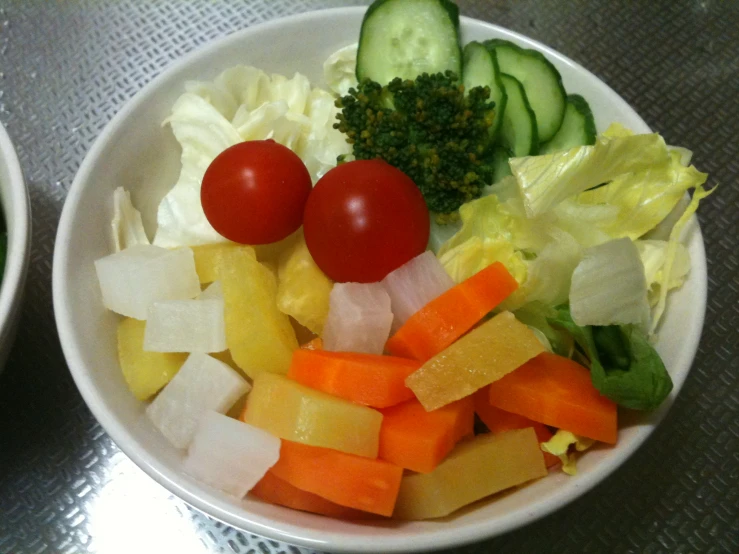 two bowls of different types of vegetables and some sort of fruit