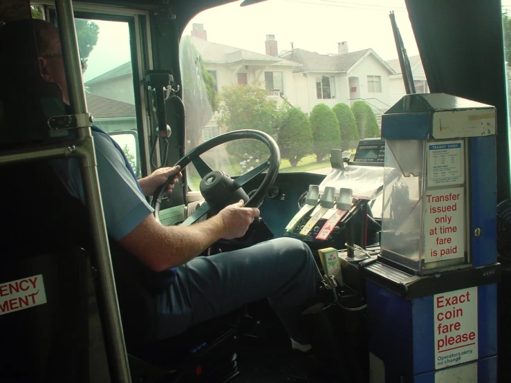 a bus driver drives next to a sign on a bus