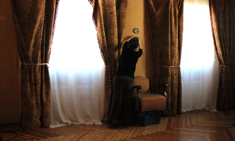 a man standing in a room with two large windows
