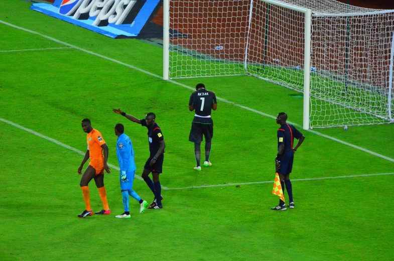 soccer players are talking to each other at the goal