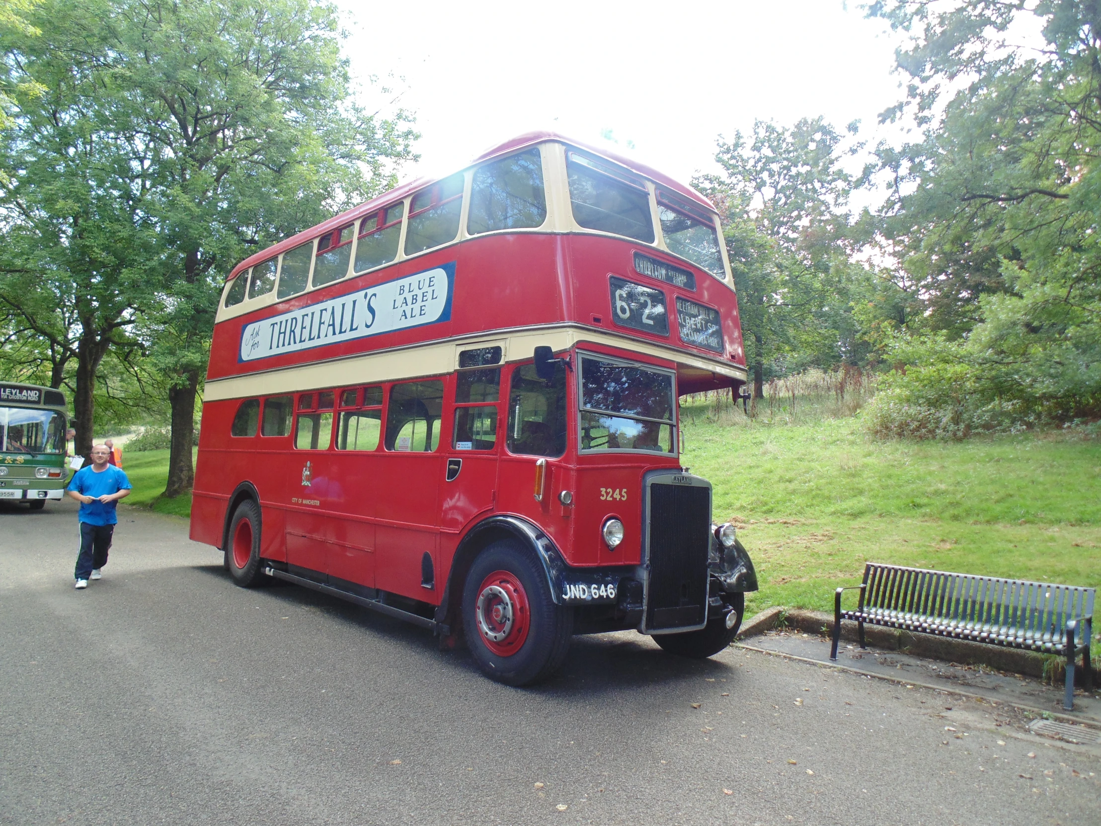 an old red double decker bus parked at the curb