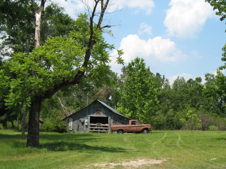 a farm house and a truck sitting on the side of the road