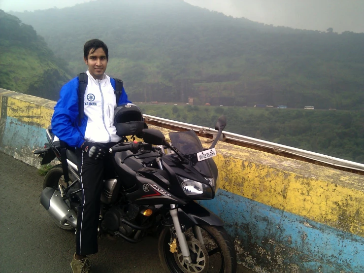 a man standing beside a parked motorcycle