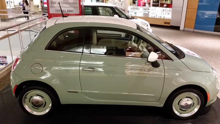 a small green car in a store with a red light