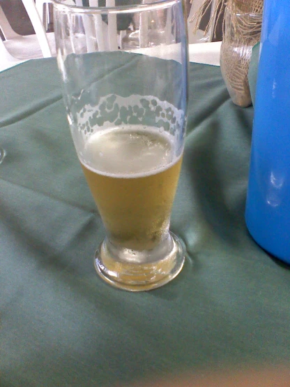 a glass of beer sitting on top of a table