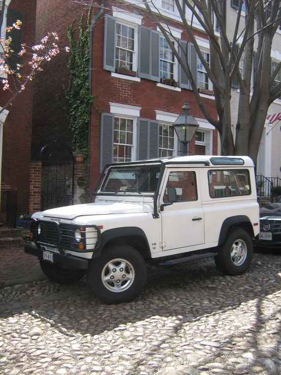 white jeep parked outside a brick house next to a brick sidewalk