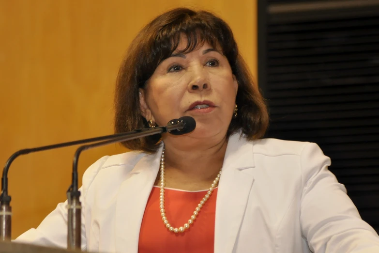 a woman standing behind a microphone making a speech