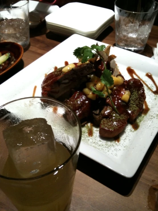 a restaurant with a square white plate filled with food