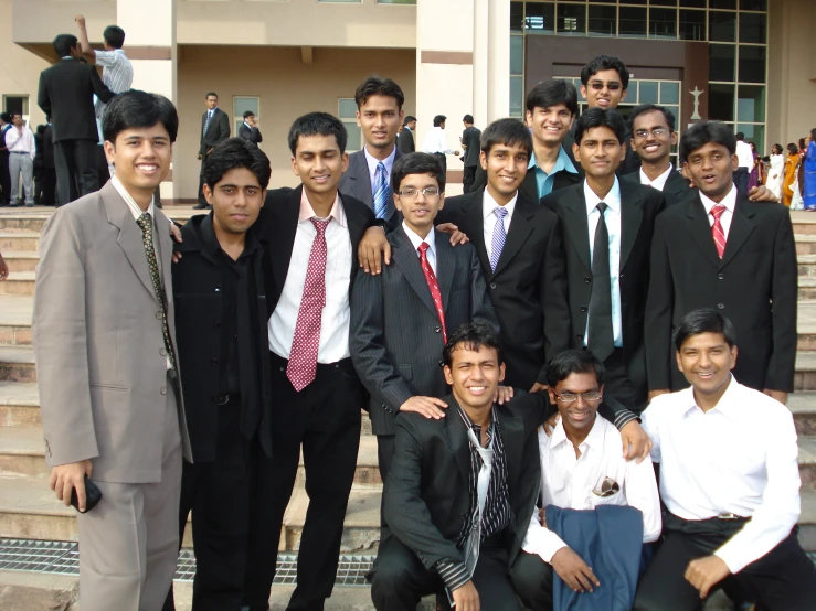 the men pose on stairs in business attire