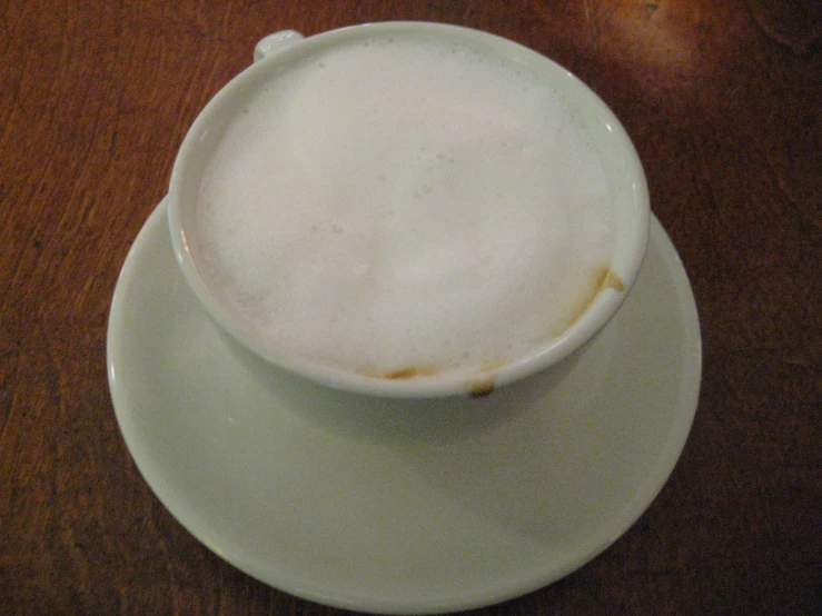 an empty white coffee cup is on a saucer
