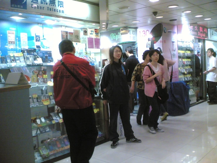 a group of people standing around in a mall with luggage