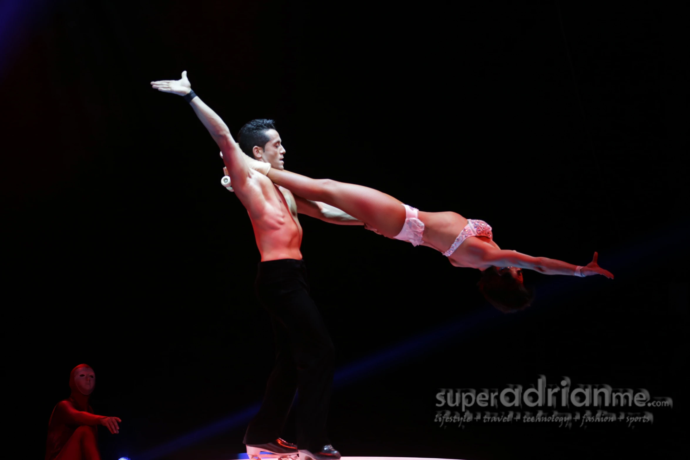 man and woman doing aerial acrobatic tricks in front of audience