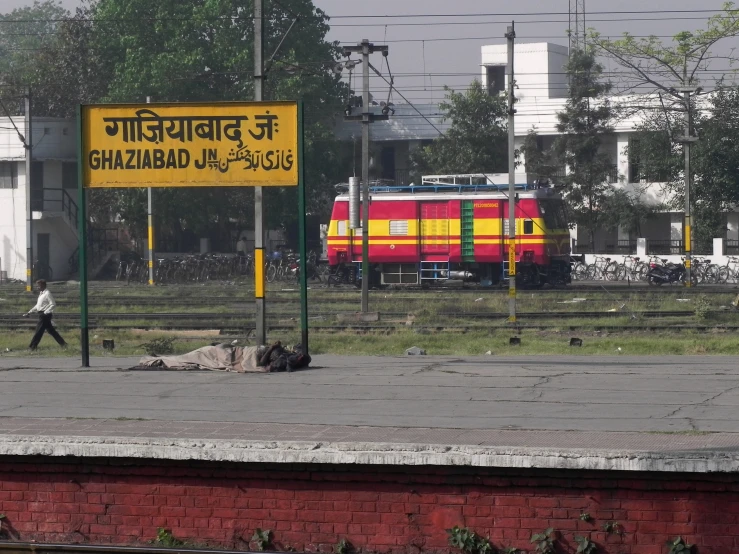 red and yellow train passing by on railroad tracks