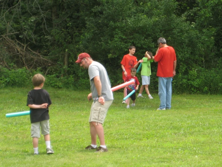 a group of children playing with plastic baseball bats