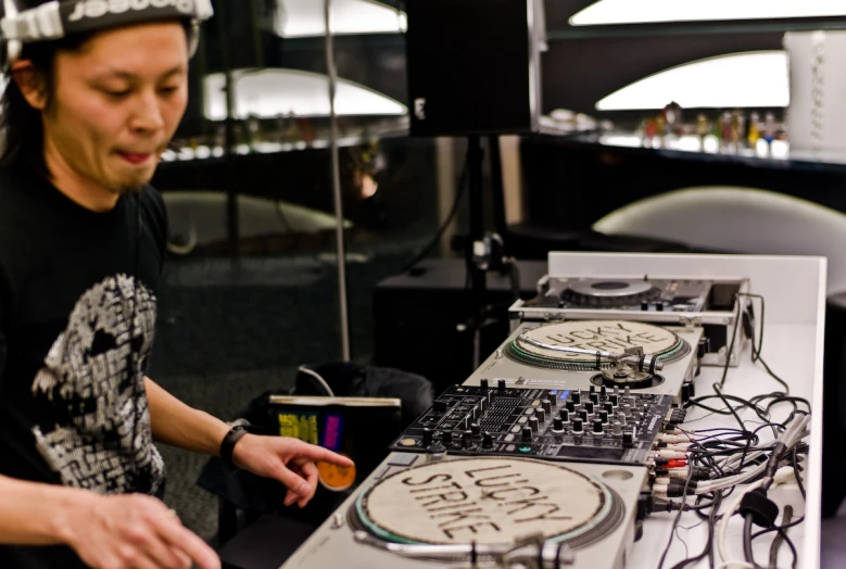 a woman is djbing at a long table