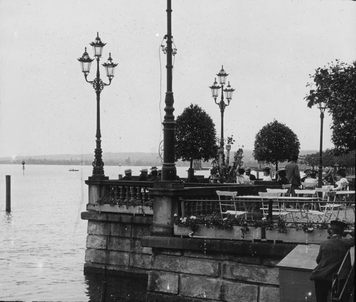 an old po of two street lights in front of a body of water