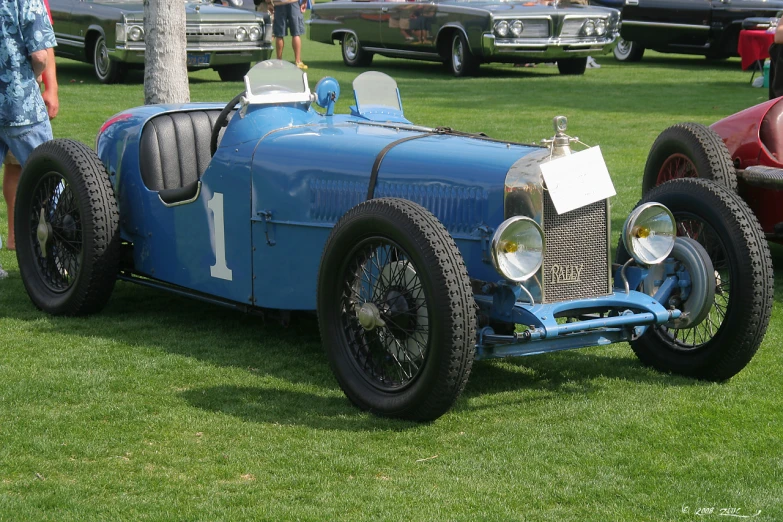 an old car sitting on top of a grass covered field