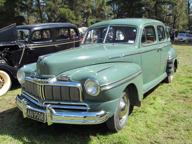 a classic car and other vintage cars are on display